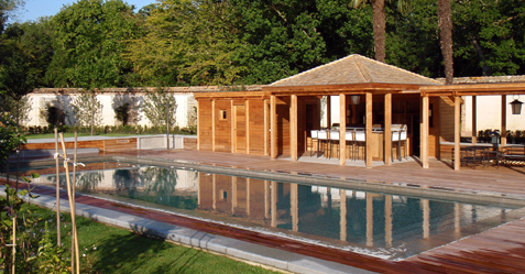 Piscine mirroir devant un bungalow au milieu d'un jardin
